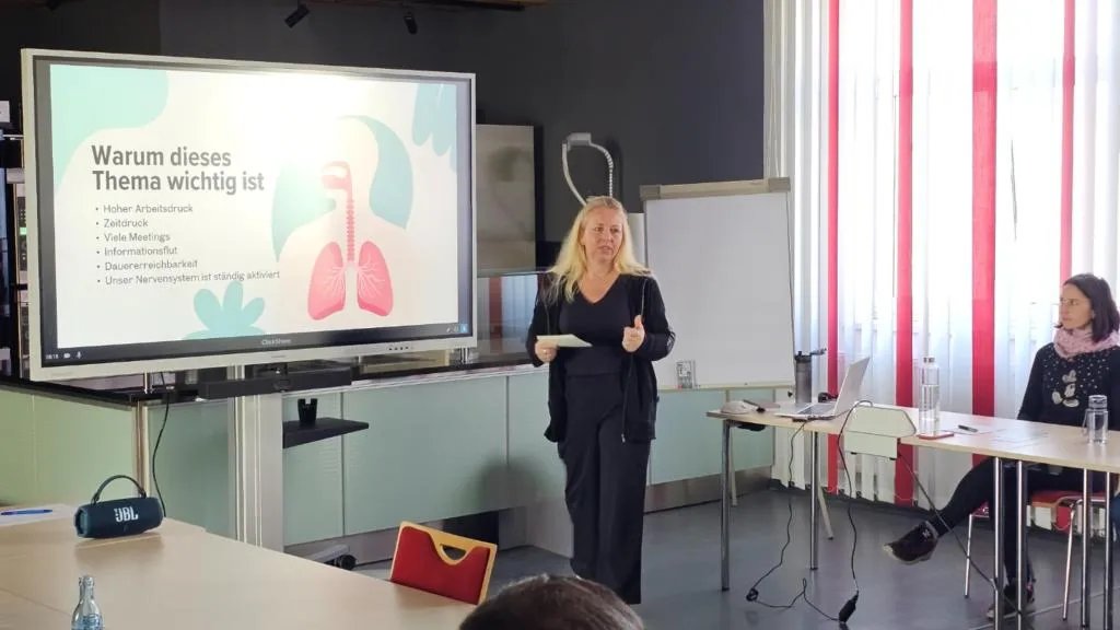 Ines Richter hält einen Atemworkshop vor Mitarbeitenden in einem Seminarraum